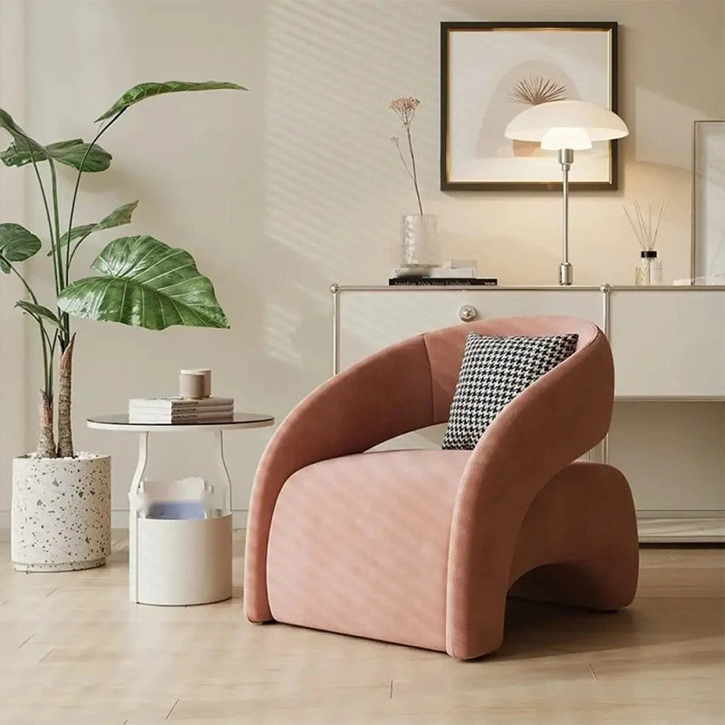 Flowing curved silhouette + living room chair + rounded chair + blush pink fabric armchair
