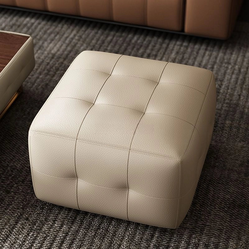 Side view image showing compact cube ottoman and footstool traits in ivory leather