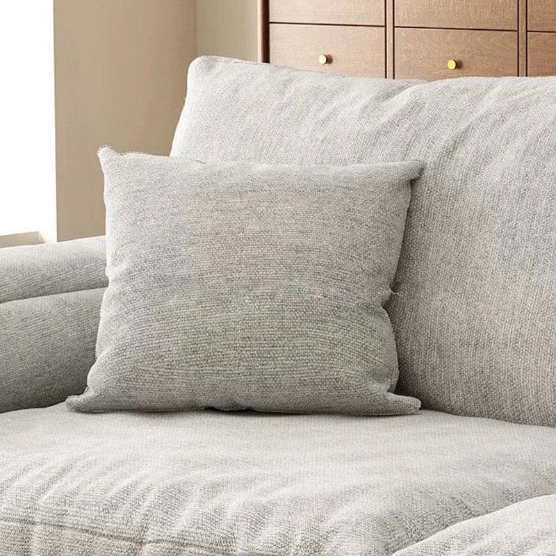 Upholstered in light grey fabric, the Rion sofa cumm bed features wide arms, plush cushions and a straight silhouette that fits modern interiors.