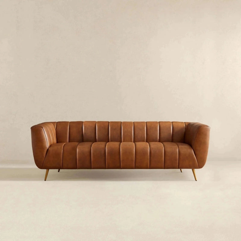 Hero view of Sabryn leather sofa featuring luxury sofa set comfort, leather couch upholstery, 3 seater sofa seating, modern living room sofa styling, vertical tufting and elegant brass finish legs