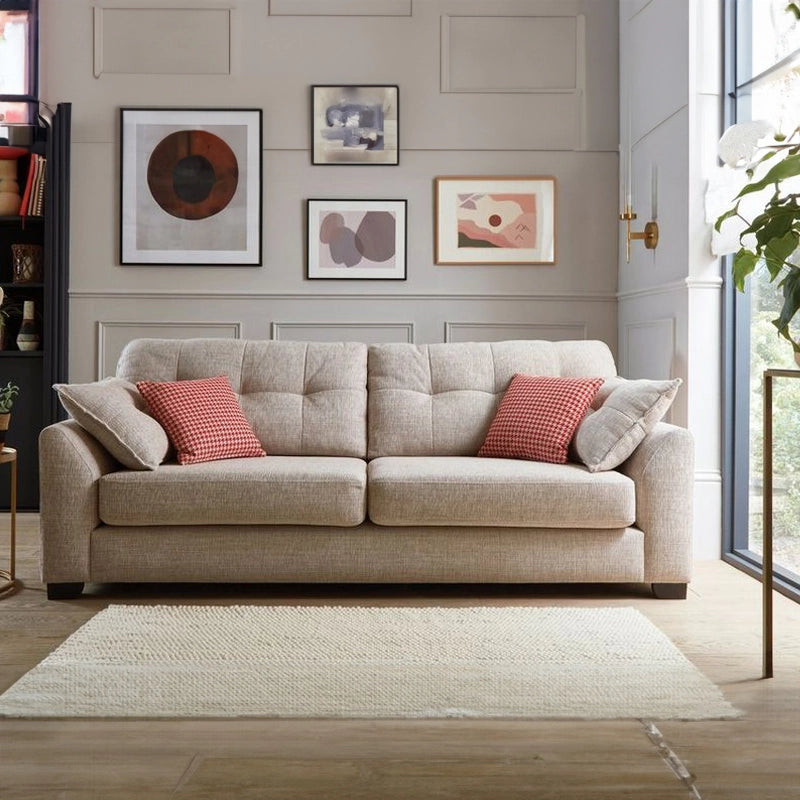 Beige sofa with red and gray cushions in a living room setting.