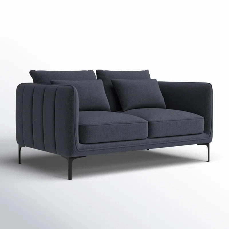 Featuring vertical channel tufted arms, deep seating, and a chic palette of tan, red, olive green, navy, and charcoal, these fabric sofas rest on elegant black stiletto legs, perfect for any stylish living room