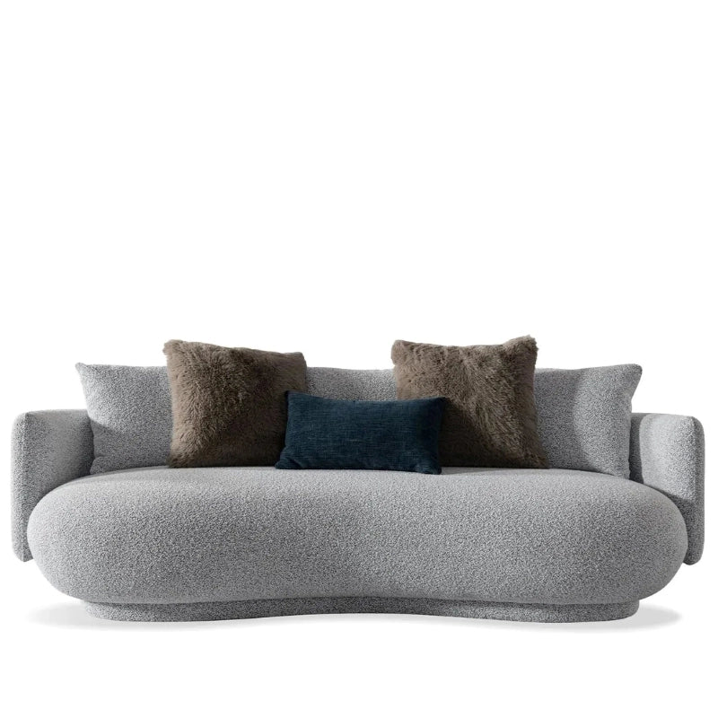 The plush seat is enriched by taupe and dark blue pillows in furry and velvet finishes.