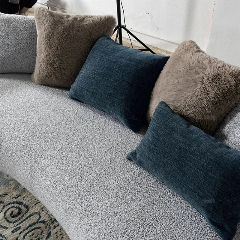 This elegantly curved three seater couch blends modern sculptural form with deep-seating comfort.