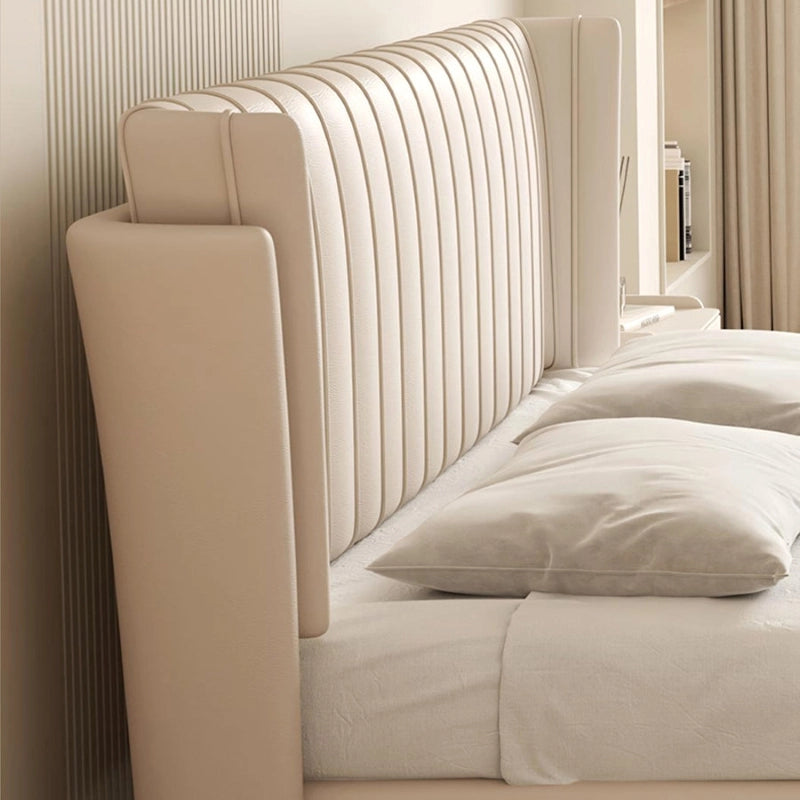 This designer bed reimagines cot design through a modern lens, blending a wingback silhouette with bold vertical channels and faux leatherette upholstery in cream, taupe, tan, or grey tones