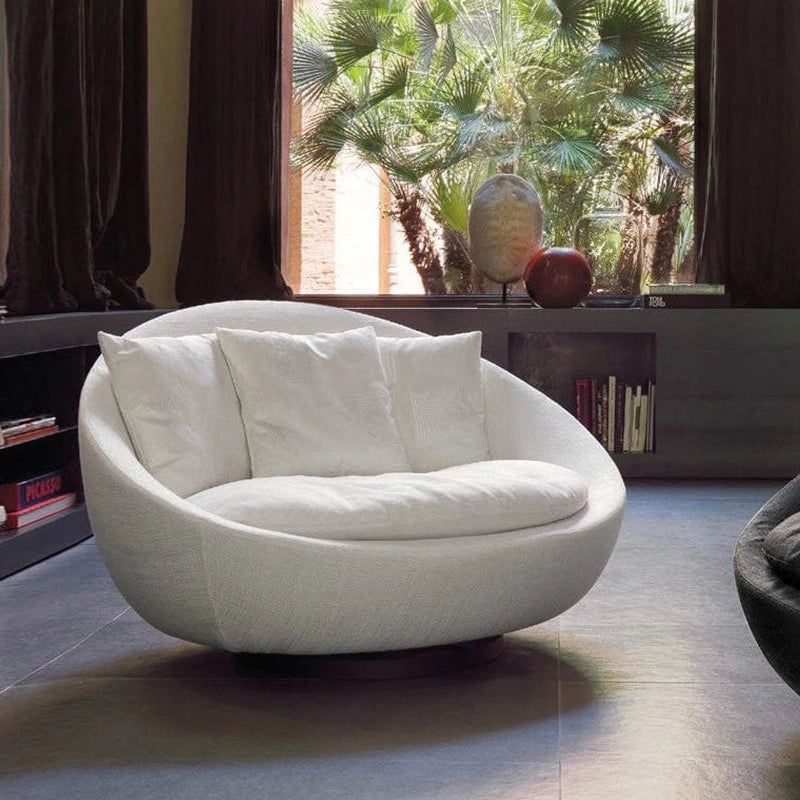 The Ravenna accent chair merges modern aesthetics with plush comfort, featuring an oversized circular frame, deep lounge seat, and an elegant low-profile swivel base