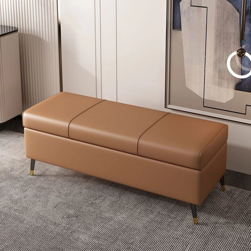 The black tapered legs tipped with brass gold lend a luxe accent, while the structured base hints at its ottoman-style utility.