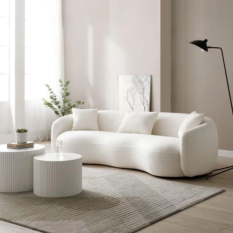 This designer sofa features a low-profile frame and tactile boucle-textured fabric, blending seamlessly into both studio flats and luxe urban homes.