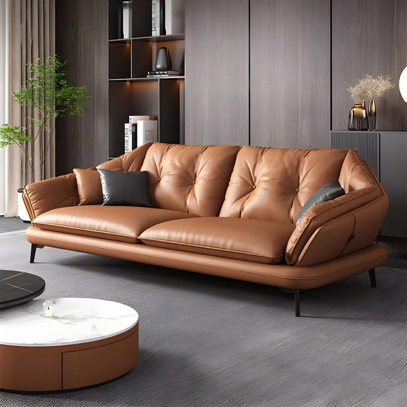 Brown leather sofa in a modern living room setting with a coffee table and decorative items.