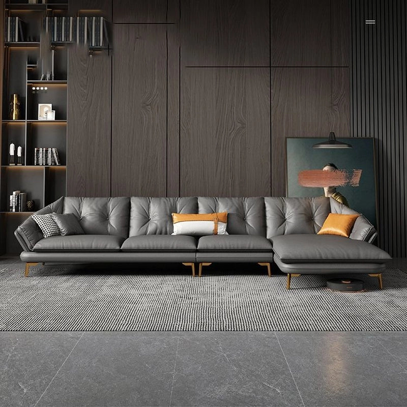 Gray sectional sofa in a modern living room with wooden walls and shelves.