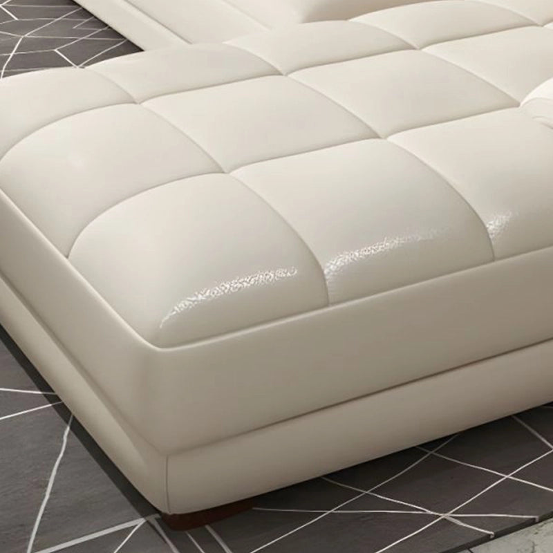 Upholstered in high-gloss pure leather across shades like cream, navy, and grey, it features deeply padded seating, adjustable headrests, and ergonomic armrests