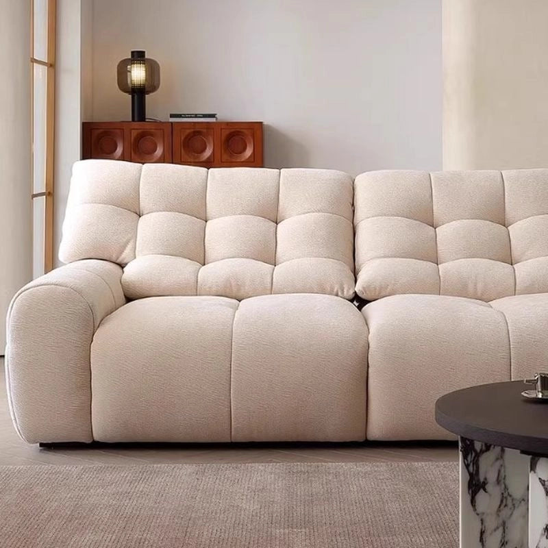 Upholstered in breathable beige fabric, its boxy silhouette supports a straight 3–4 seat layout with ground-touch form.